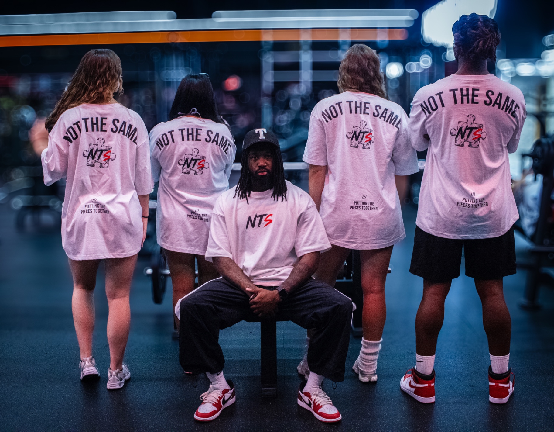 NTS crew wearing the Not The Same tee, showing the full back print